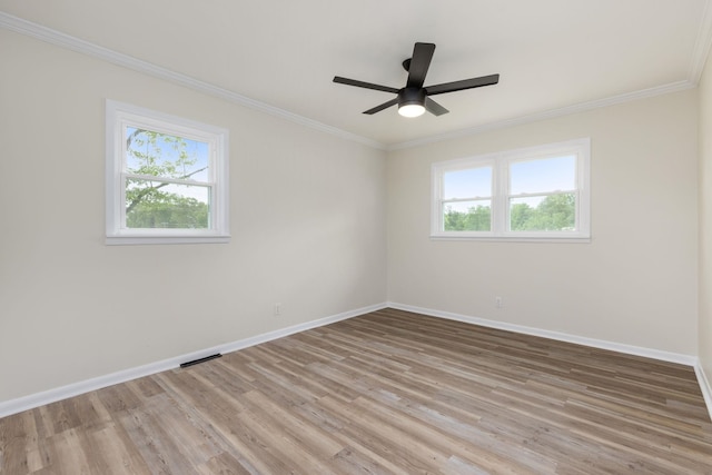 unfurnished room featuring baseboards, light wood finished floors, and a wealth of natural light