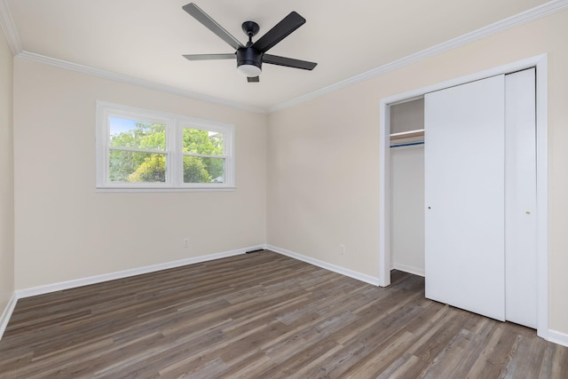 unfurnished bedroom featuring ceiling fan, crown molding, wood finished floors, baseboards, and a closet