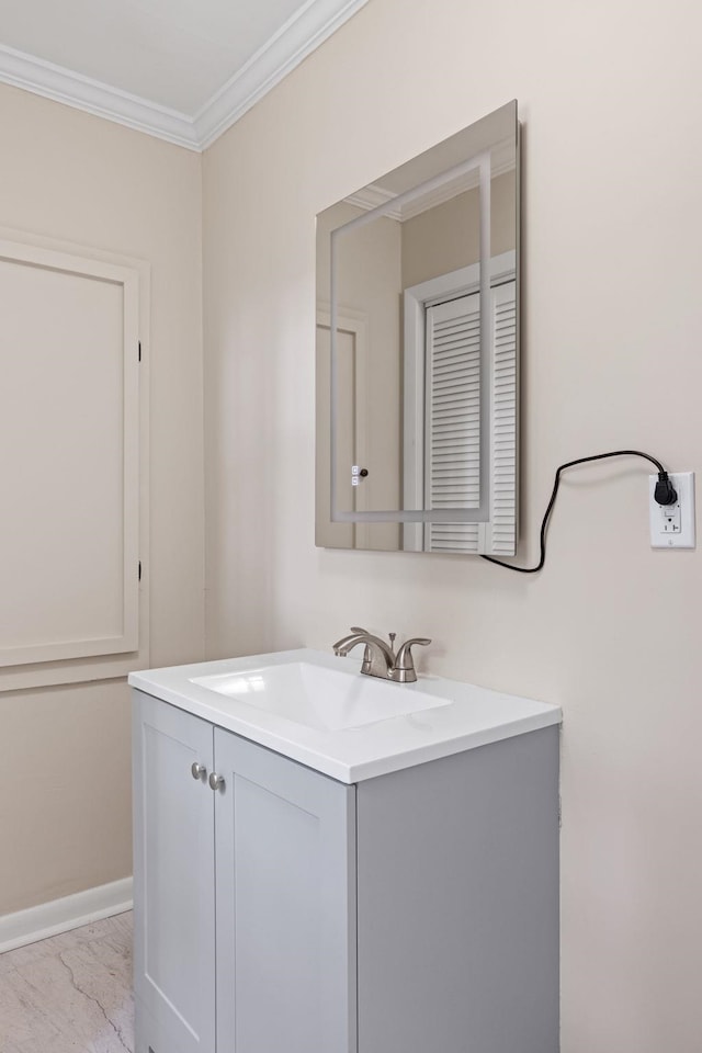 bathroom featuring vanity, marble finish floor, crown molding, and baseboards