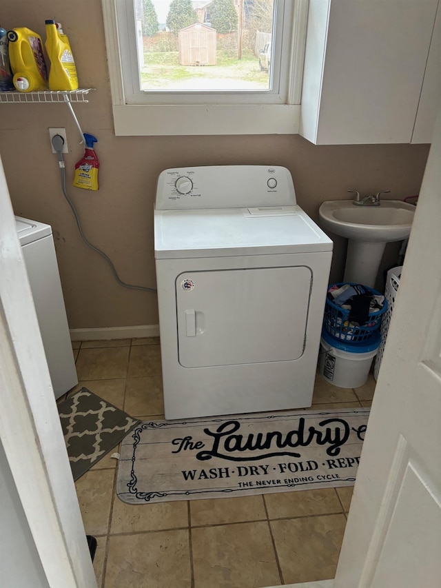 laundry room with cabinets, washer and clothes dryer, and tile patterned flooring