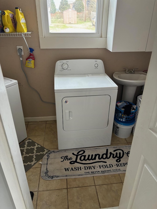 laundry area with cabinets, tile patterned floors, and washer and clothes dryer