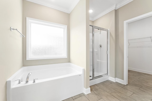 bathroom featuring ornamental molding and separate shower and tub