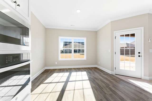 unfurnished living room with crown molding, plenty of natural light, and dark hardwood / wood-style flooring