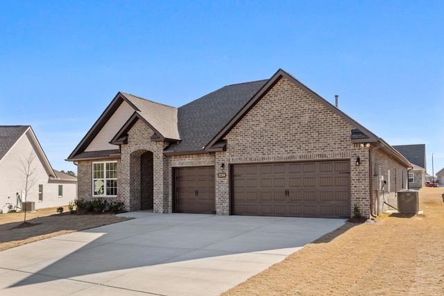 view of front of property featuring central AC unit and a garage