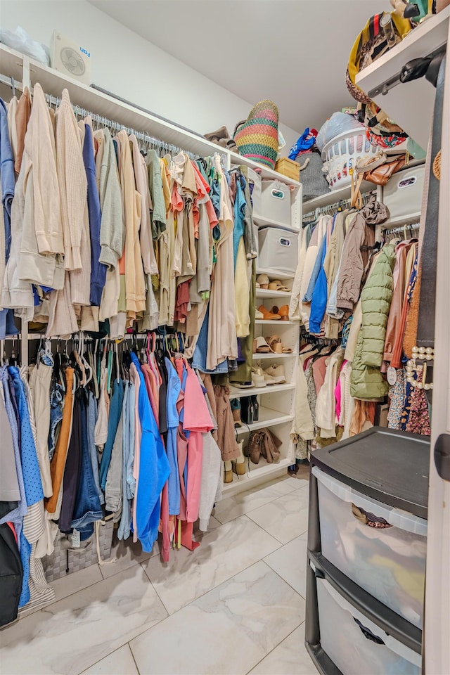 walk in closet with marble finish floor