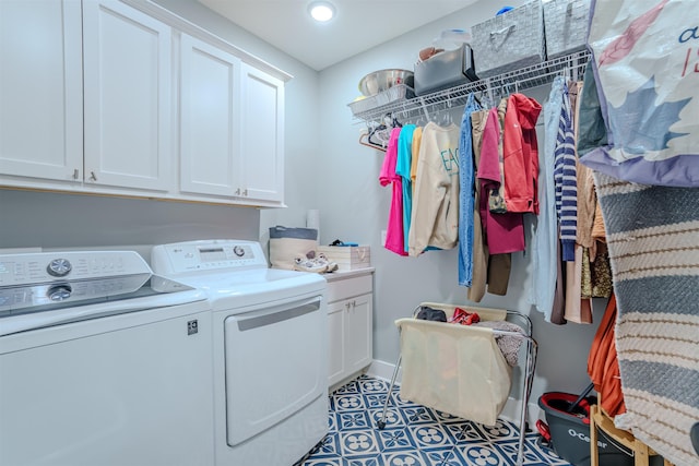 washroom featuring cabinet space, baseboards, washer and clothes dryer, and dark tile patterned flooring