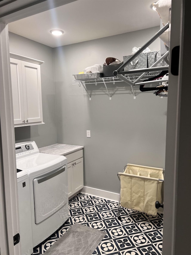 laundry area featuring tile patterned flooring, washing machine and dryer, and cabinets