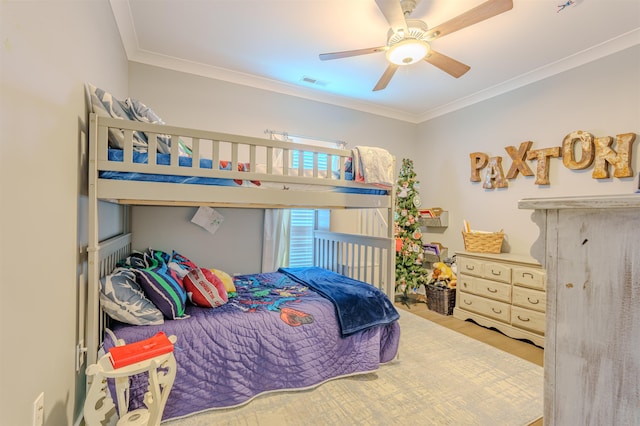 bedroom with a ceiling fan, visible vents, and crown molding