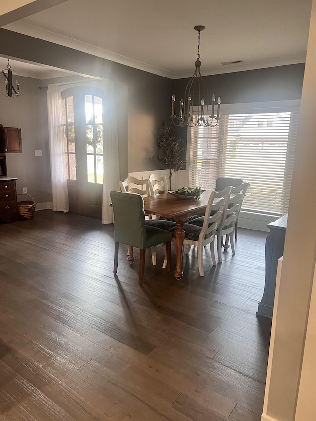 dining room featuring dark wood-style floors, visible vents, a chandelier, and ornamental molding