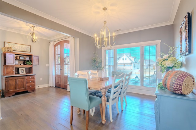 dining area with a chandelier, french doors, wood finished floors, and crown molding