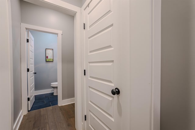 hallway with baseboards and dark wood-style flooring