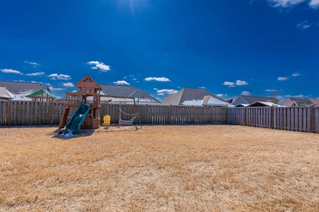 view of yard featuring a playground and a fenced backyard