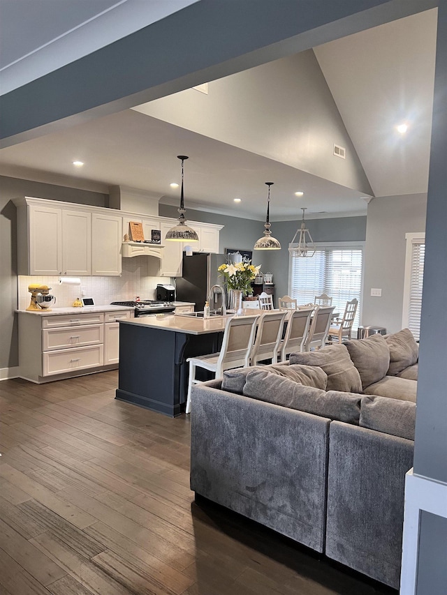 living area with baseboards, visible vents, lofted ceiling, dark wood-type flooring, and recessed lighting