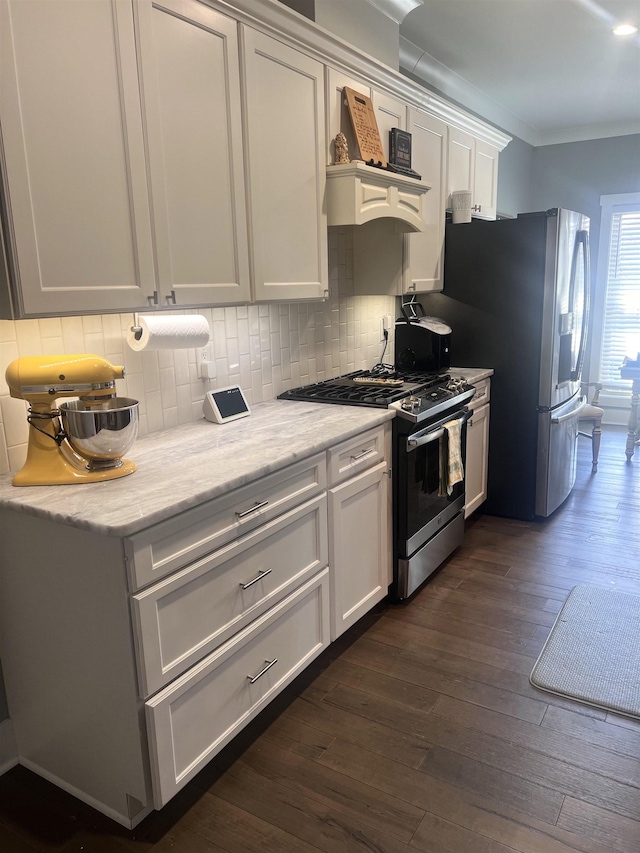 kitchen featuring dark wood-style floors, stainless steel appliances, decorative backsplash, and white cabinets