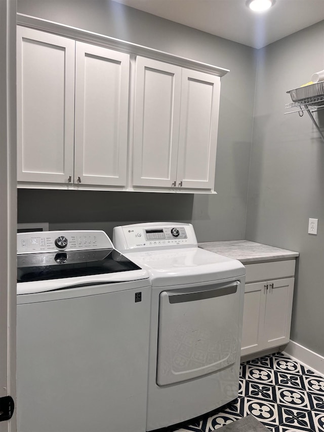 laundry room featuring baseboards, cabinet space, and washer and dryer