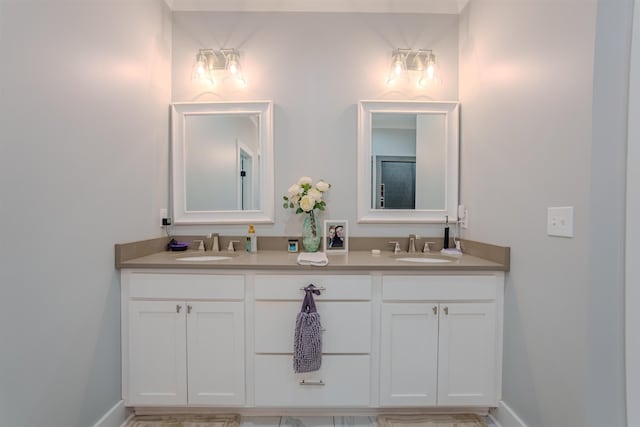 bathroom featuring double vanity, baseboards, and a sink