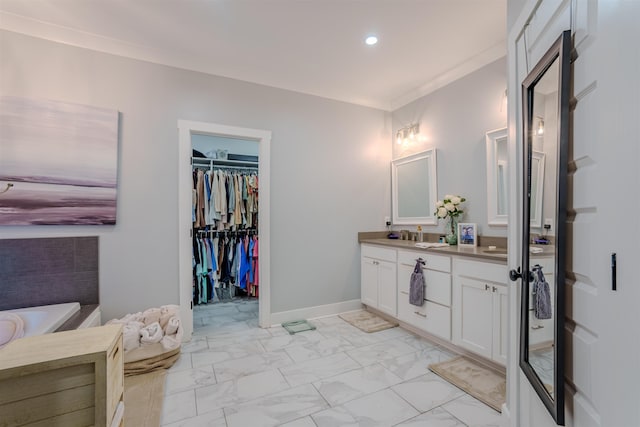 full bath with a washtub, marble finish floor, double vanity, ornamental molding, and baseboards