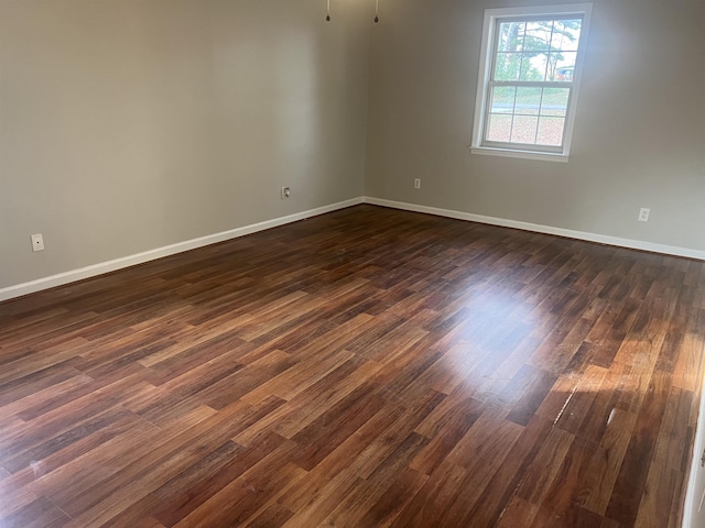 empty room with dark hardwood / wood-style flooring