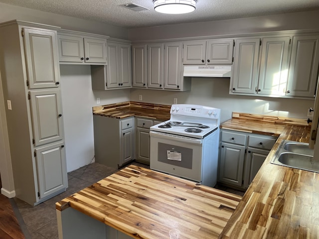 kitchen with white electric range oven, a textured ceiling, butcher block counters, and sink