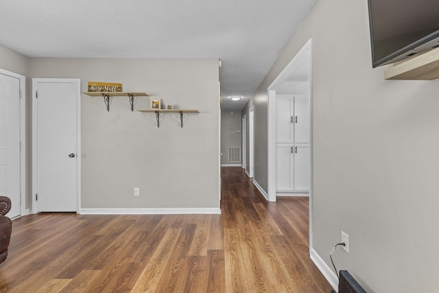  - corridor featuring wood finished floors and a textured ceiling