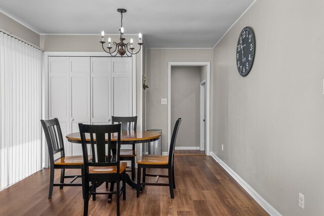  - dining space with a chandelier, dark wood finished floors, and crown molding