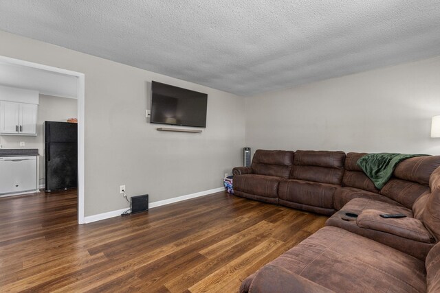  - living area with dark wood-style flooring and a textured ceiling