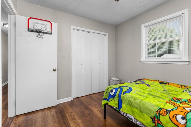  - bedroom with wood finished floors, a closet, and a textured ceiling