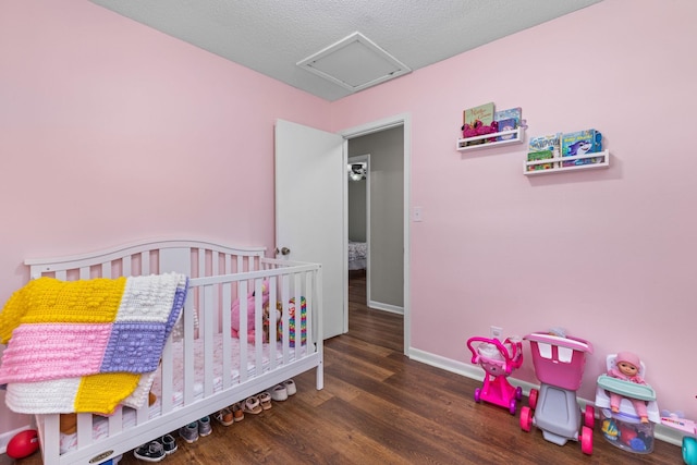  - bedroom featuring attic access, wood finished floors, and a crib