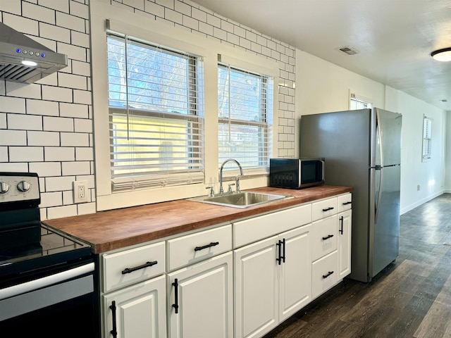 kitchen featuring sink, backsplash, stainless steel electric range oven, and wood counters