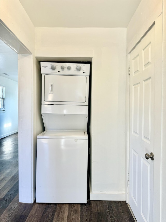 laundry room featuring stacked washer / dryer and dark hardwood / wood-style floors