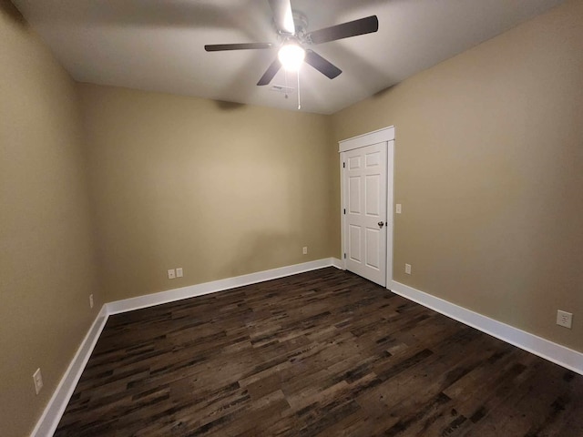 spare room featuring ceiling fan and dark wood-type flooring