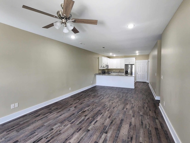 unfurnished living room with dark hardwood / wood-style floors, ceiling fan, and sink