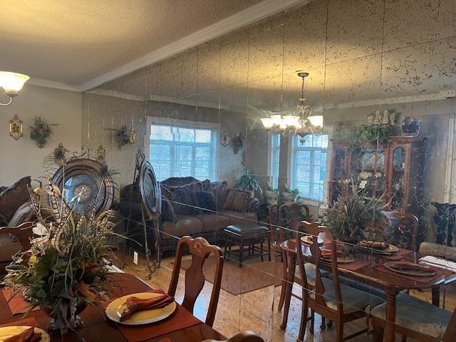 dining space with crown molding and a chandelier