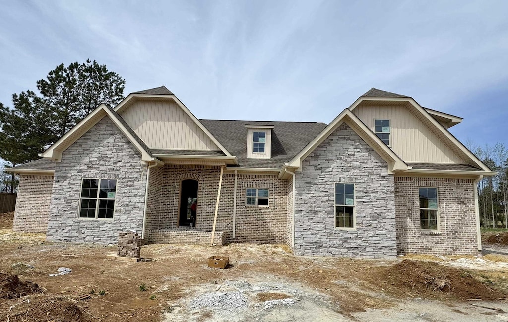 craftsman house with stone siding, board and batten siding, and a shingled roof
