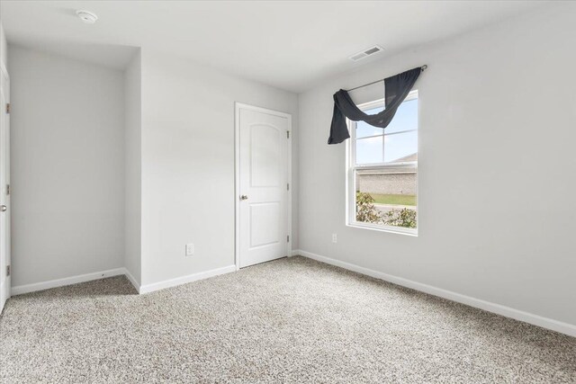  - carpeted empty room featuring baseboards and a smoke detector