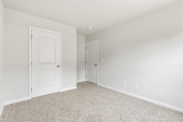 - unfurnished bedroom featuring light carpet and baseboards