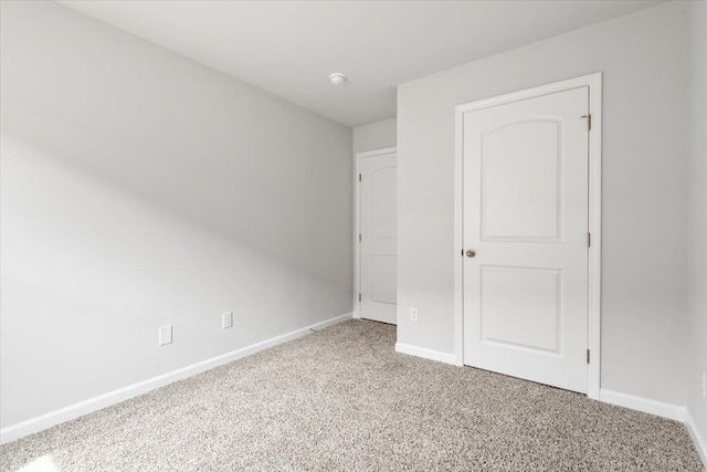  - unfurnished bedroom featuring light carpet and baseboards