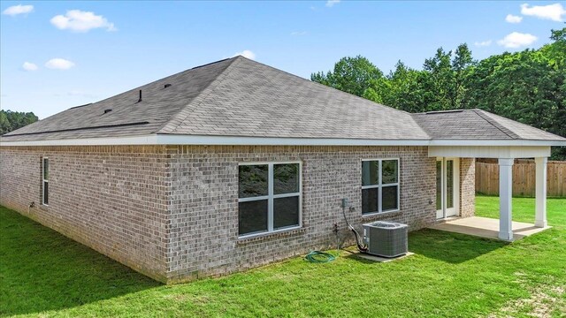  - rear view of property with central AC unit, a shingled roof, a patio area, and brick siding