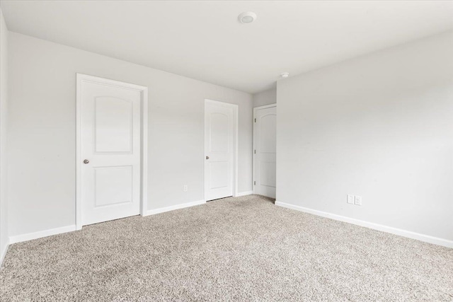  - unfurnished bedroom featuring light carpet and baseboards
