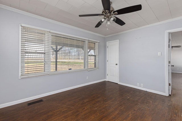 spare room featuring visible vents, a ceiling fan, wood finished floors, crown molding, and baseboards