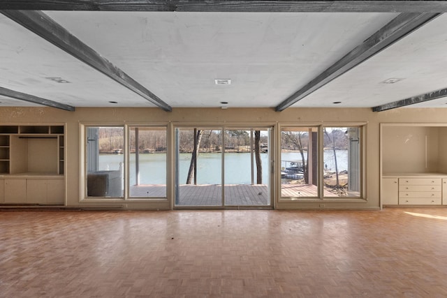 interior space featuring beamed ceiling, parquet flooring, and a water view