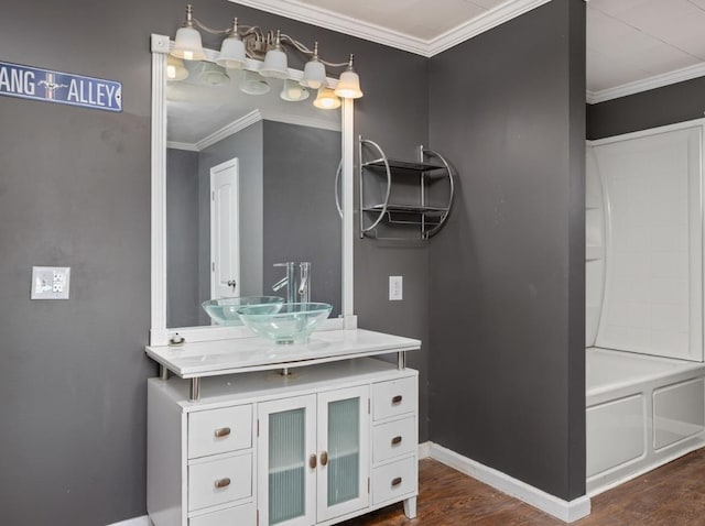 bathroom featuring vanity, wood finished floors, baseboards, and ornamental molding