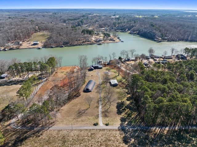 birds eye view of property featuring a wooded view and a water view