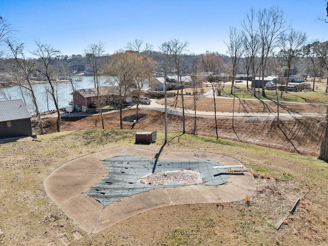 view of yard featuring a covered pool, a water view, and a patio