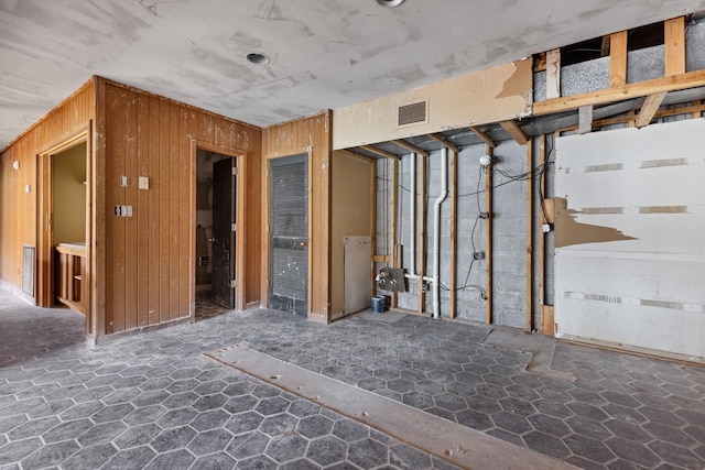 misc room with visible vents and wooden walls