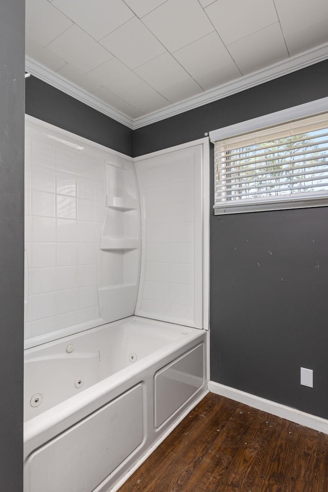 full bathroom featuring ornamental molding, a combined bath / shower with jetted tub, baseboards, and wood finished floors