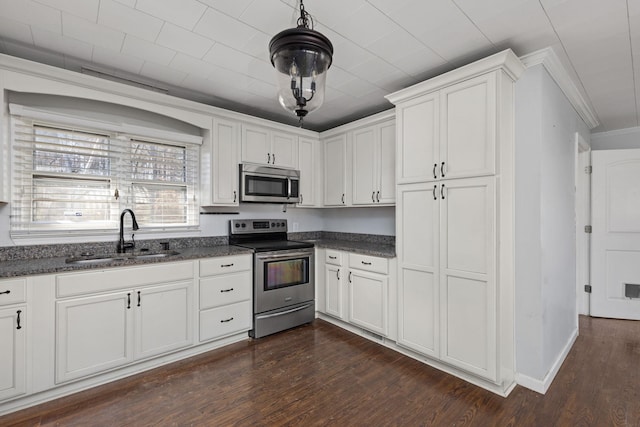 kitchen featuring ornamental molding, a sink, dark wood-style floors, white cabinetry, and stainless steel appliances