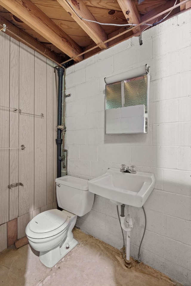 bathroom featuring toilet, concrete flooring, and sink