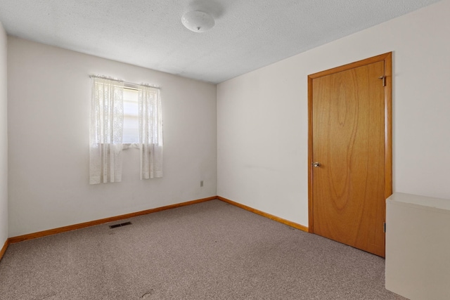 carpeted spare room featuring a textured ceiling