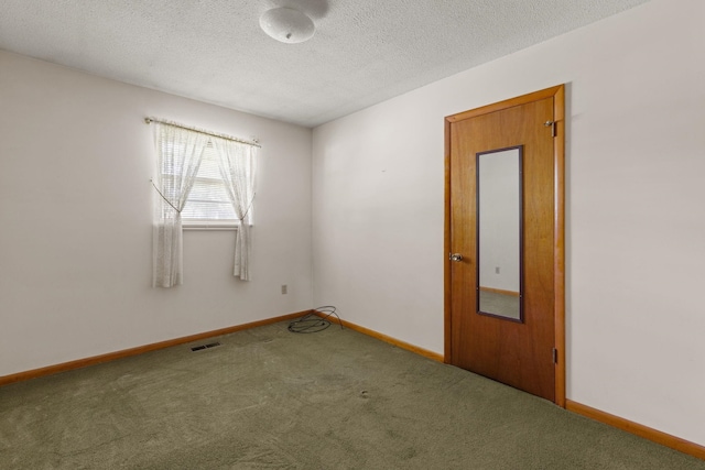 carpeted empty room with a textured ceiling